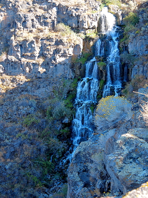 [Waterfall with at least six levels as it drops down the canyon wall. Vegetation is growing on the canyon wall near this water.]